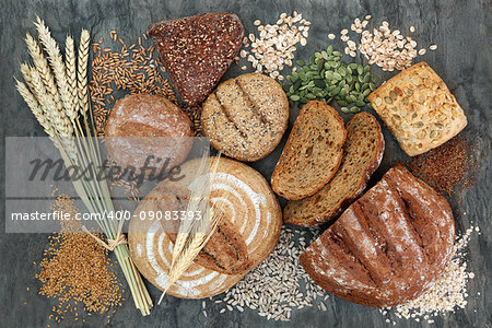 High dietary fiber health food concept with multi seed whole grain rolls, seeds, nuts and cereals on marble background top view. Foods high in omega 3 fatty acids, antioxidants and vitamins.