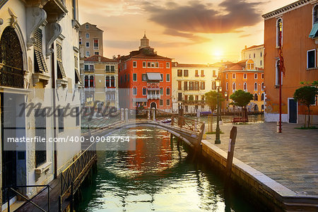 Venetian cityscape with water canal and small bridge at sunrise, Italy
