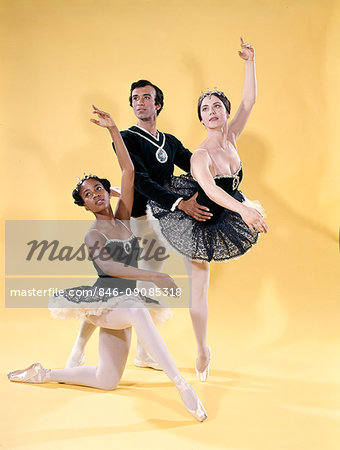 1970s BALLET DANCERS CAUCASIAN WOMAN ON POINT HISPANIC MAN AFRICAN AMERICAN WOMAN POSED KNEELING WEARING TUTUS AND TIGHTS