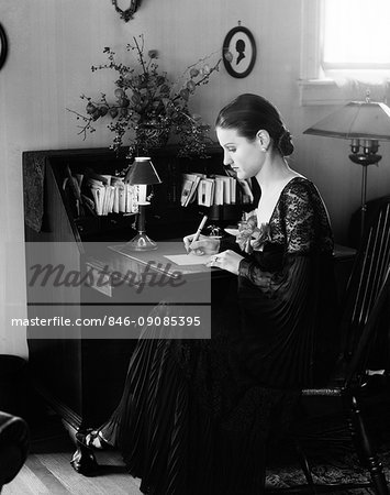 1930s WOMAN SITTING AT DESK WRITING LETTER
