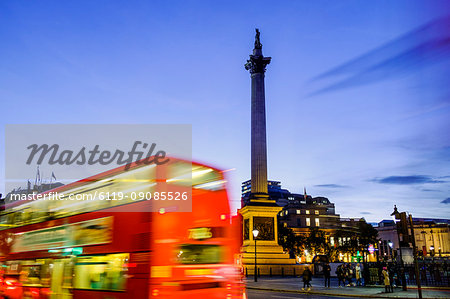 Red bus passing Nelson's Column in Trafalgar Square, London, England, United Kingdom, Europe