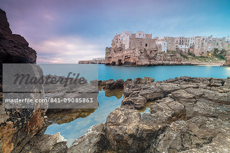 Turquoise sea at sunrise framed by the old town perched on the rocks, Polignano a Mare, Province of Bari, Apulia, Italy, Europe