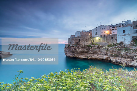 Turquoise sea at sunrise framed by the old town perched on the rocks, Polignano a Mare, Province of Bari, Apulia, Italy, Europe