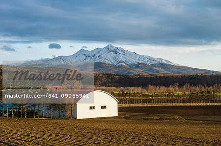 Little farm before a snow capped mountain near the Shiretoko National Park, Hokkaido, Japan, Asia