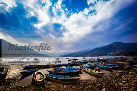 Boats docked on a lake at sunset in Pokhara, Nepal, Asia