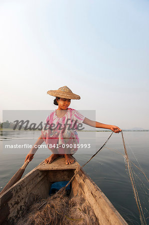 A young woman pulls in her nets at the end of the day on Indawgyi Lake, Kachin State, Myanmar (Burma), Asia