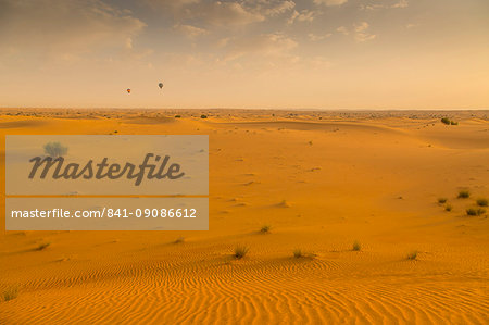 Hot air balloons over sand dunes at sunrise in the Dubai Desert, Dubai, United Arab Emirates, Middle East