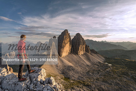 Sesto / Sexten, province of Bolzano, Dolomites, South Tyrol, Italy. A mountaineer admires the sunset at the Three Peaks of Lavaredo