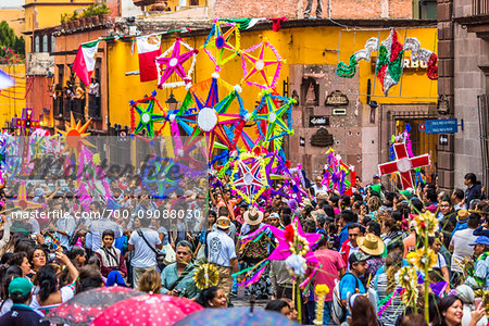 Crowded street with colorful decorations at the St Michael Archangel Festival procession in San Miguel de Allende, Mexico