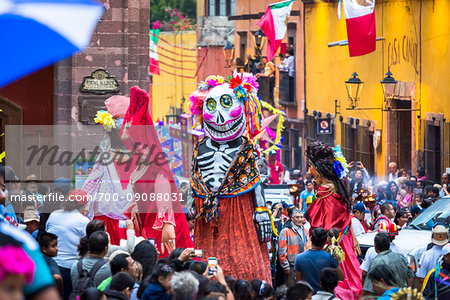 Mojigangas, giant puppets and people crowding the street during the St Michael Archangel Festival procession in San Miguel de Allende, Mexico