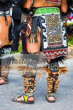 Men's legs of indigenous tribal dancers in traditional costume at the St Michael Archangel Festival parade in San Miguel de Allende, Mexico