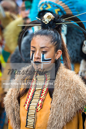 Close-up portrait of a female, indigenous tribal dancer with painted face in the St Michael Archangel Festival parade in San Miguel de Allende, Mexico