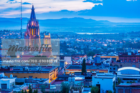 Overview of the city with the towers of the Parroquia de San Miguel Arcangel illuminated at dusk, San Miguel de Allende in Guanajuato State, Mexico