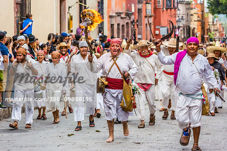 Men in traditional clothing walking through the streets re-enacting the historic peasant revolt for Mexican Independence Day celebrations in San Miguel de Allende, Mexico