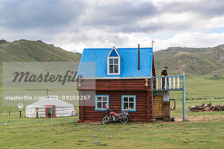 Mongolian man on the terrace of his wooden house. Tariat district, North Hangay province, Mongolia.