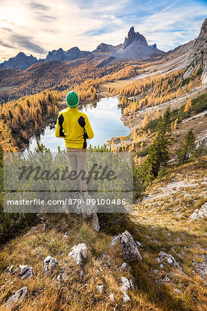 Hiker admiring the autumn colors at Federa lake, Cortina d Ampezzo, Belluno, Dolomites, Veneto, Italy