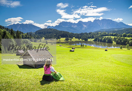 A girl in typical dress looks at the Geroldsee. Gerold, Garmisch Partenkirchen, Bayern, Germany