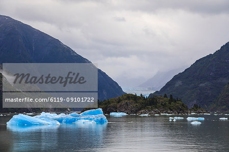 Blue icebergs and face of Sawyer Glacier, mountain backdrop, Stikine Icefield, Tracy Arm Fjord, Alaska, United States of America, North America