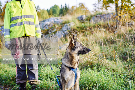 Volunteer with dog helping emergency services find missing people