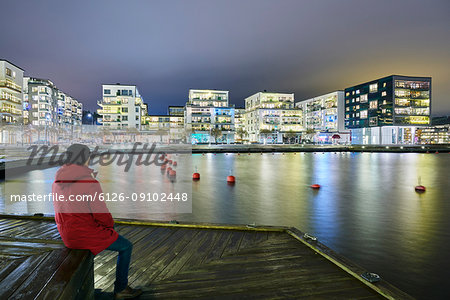 Man sitting at waterfront in Stockholm, Sweden