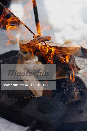 Sausage being heated in fire