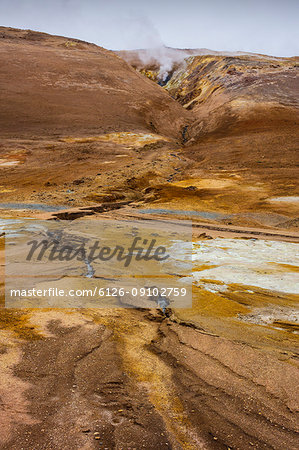 Steam over hot springs among rocky mountains in Iceland Steam over hot springs among rocky mountains in Iceland
