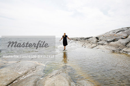 Rear view of mature woman wading in sea in the Stockholm archipelago
