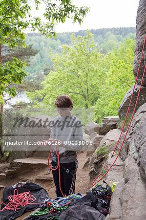 Boy with climbing ropes in mountains