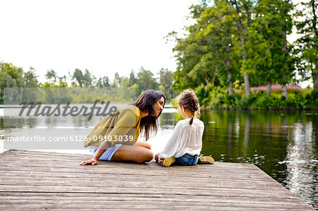 Mother and daughter on pier beside lake in Friseboda, Sweden Mother and daughter on pier beside lake in Friseboda, Sweden