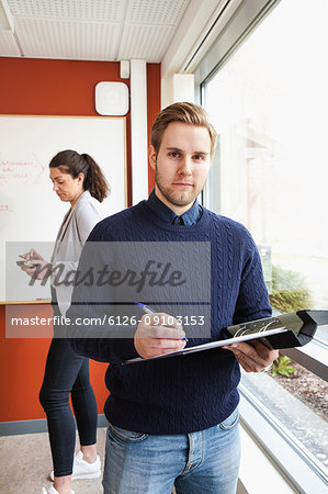 Businessman holding ring binder in office