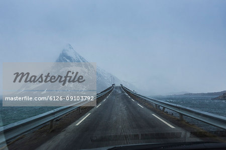 A bridge with a view of snow capped mountains in Norway