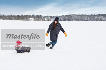 Mother playing with child in snow in Sweden