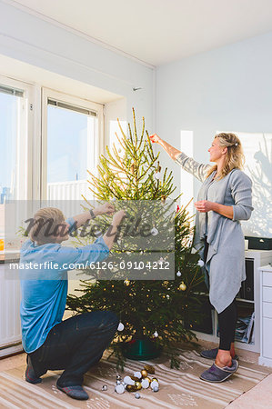 Couple decorating christmas tree together