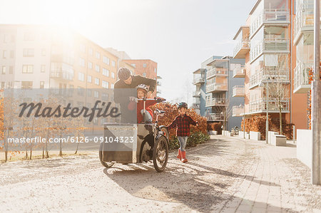 Man cycling with his sons in Stockholm