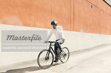 Man on smart phone while bicycling in Sweden