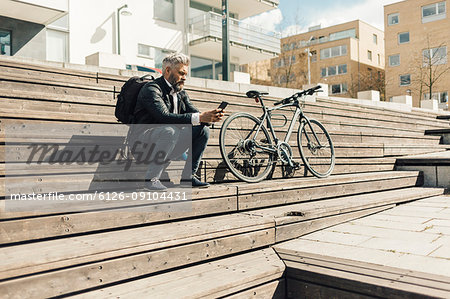 Man on staircase with bicycle in Sodermanland, Sweden