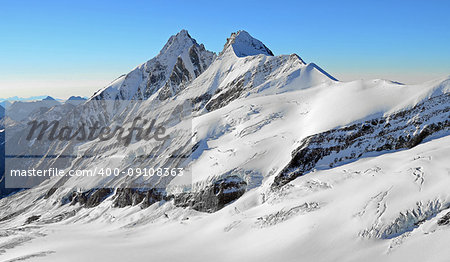 high snowy mountain peaks and glaciers rocks with blue sky, freedom