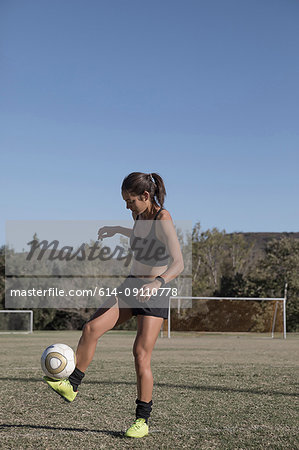 Woman on football pitch playing football