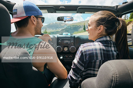 Road trip couple driving on rural road, Breckenridge, Colorado, USA