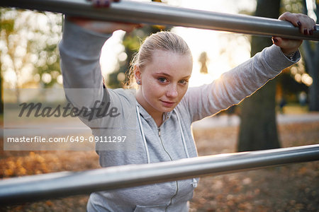 Curvaceous young woman training, portrait leaning against handrail in park