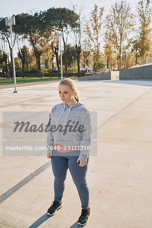 Curvaceous young woman training, standing staring