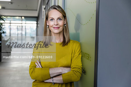 Portrait of confident mature businesswoman in office corridor Portrait of confident mature businesswoman in office corridor