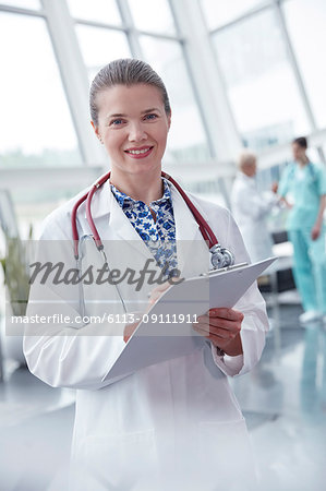 Portrait smiling, confident female doctor with clipboard in hospital
