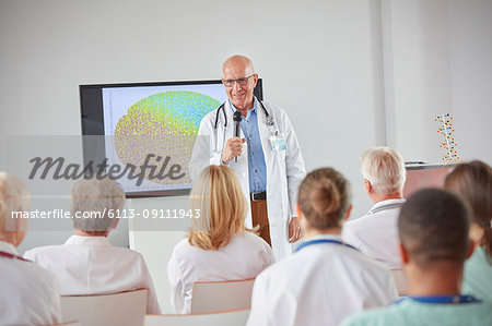 Male surgeon with microphone leading conference