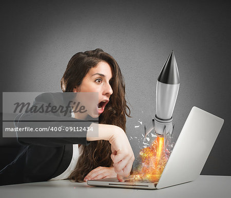 Businesswoman launches a fast rocket from a laptop. concept of company startup