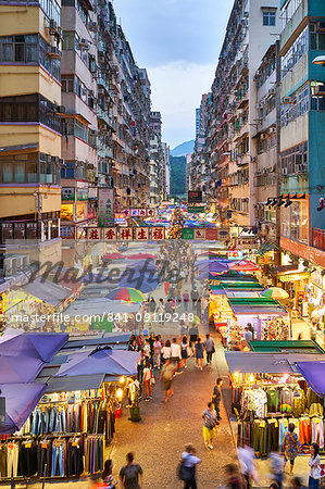 A busy market street in Mong Kok (Mongkok) lit up at dusk, Kowloon, Hong Kong, China, Asia