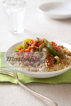 Spicy ground beef with peppers and couscous  on a green napkin with a fork