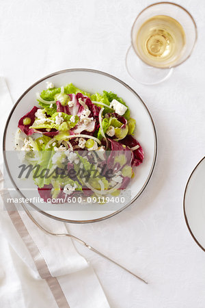 Romaine and endive salad with a glass of white wine