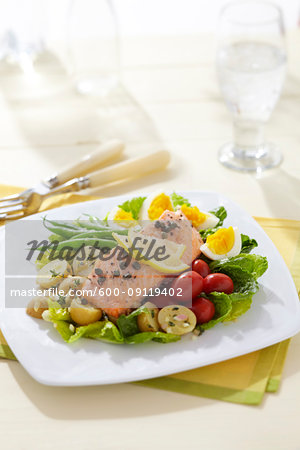 Salmon Nicoise salad with green beans, egg, potatoes, cherry tomatoes on a bed of letttuce