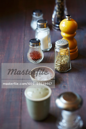 Still life of salt and pepper shakers on a purple background